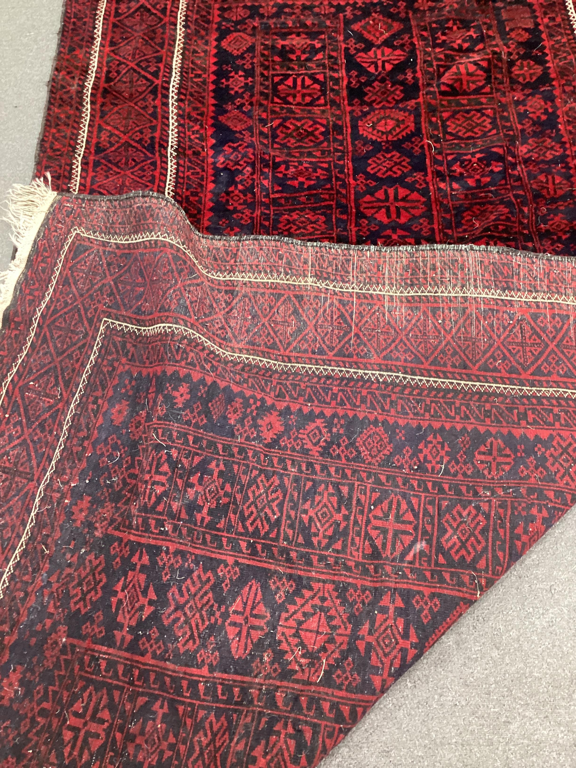 A Belouch blue ground geometric rug, 244cm x 120cm